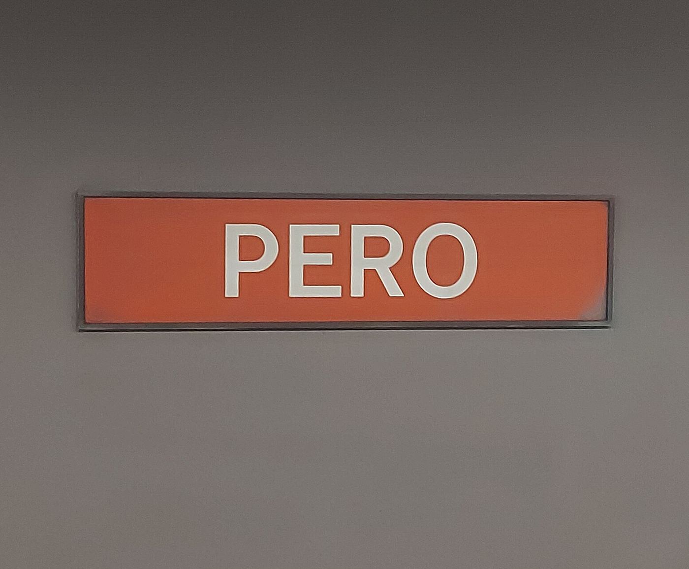 Il cartello rosso con la scritta PERO sulla parete della stazione della metropolitana M1