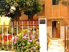 Il cancello d'ingresso con le ortensie fiorite e la targa del B&B
